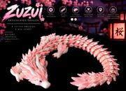 Acusinkt ZUZUI infografiek: beweegbare draak van 46 cm in wit en roze met kersenbloesems en paarse ogen voor een sakura-achtergrond met torii en lantaarn, met de kenmerken volledig beweegbaar, 3 kleuren, handgemaakt met zorg in België en een perfect cadeau voor verzamelaars en dromers