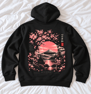 Zwarte Mount Fuji hoodie, achterkant op wit laken: Fuji, roze zon, sakura, pagode, meer, lantaarn en zittende figuur