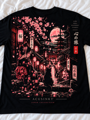 Detail van de achterkant van het zwarte Zen Harmony T-shirt op een wit laken: geisha in bloemenkimono met een kat, sakura-takken, lantaarns, roze maan, pagode en torii in roze, rode en crème tinten